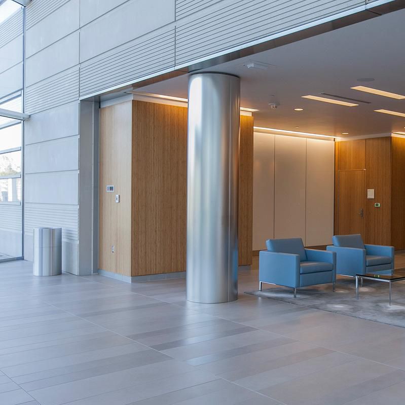 Brushed stainless steel cylindrical column cladding in a contemporary lobby