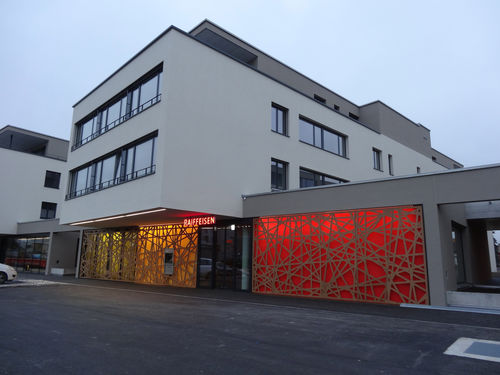 Pannello decorativo per esterni - RAIFFEISEN BANK HEIMBERG - Bruag Design Factory AG - da parete / retroilluminato / in HPL
