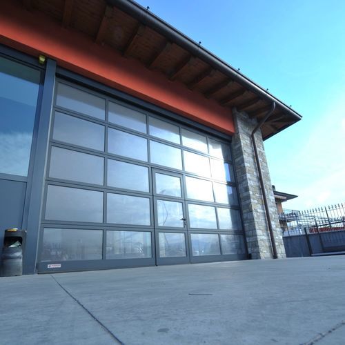 Porta industriale sezionale - SECTIONAL GLASS - Moreschi Chiusure Industriali S.r.l. - in alluminio / in acciaio / in acciaio galvanizzato
