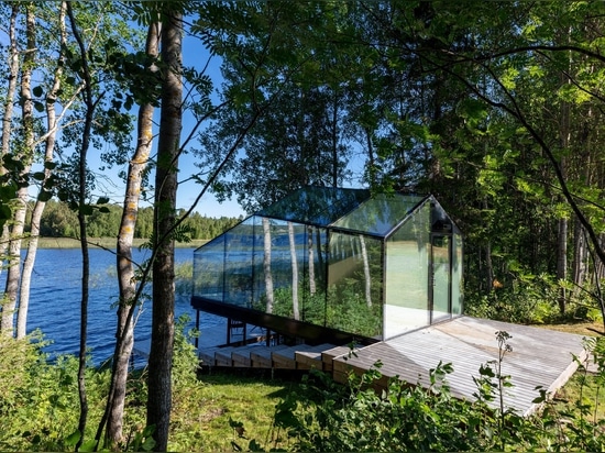 La cabina di vetro a specchio con vista panoramica scompare nel ricco paesaggio naturale della Finlandia