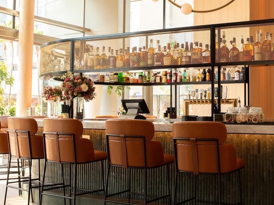 Ambiente bar industrial-chic con struttura in rete metallica e sedute contemporanee presso Ace Porter
