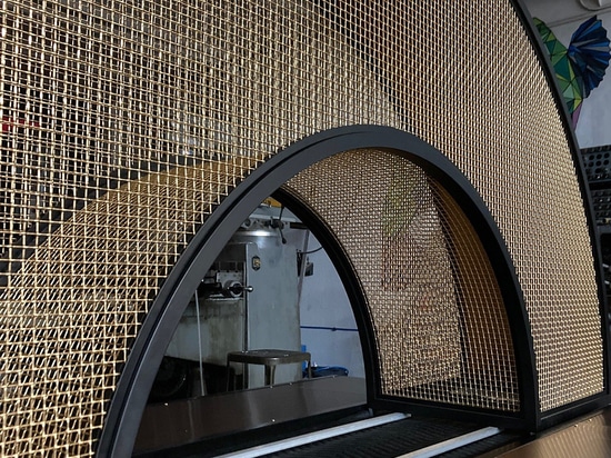 Arco curvo in rete di bronzo progettato e realizzato da Desposito Designs per il bar Ace Porter dell'Omni San Diego