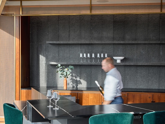 Rete metallica tessuta decorativa installata nell'interior design aziendale come portale sopra un bar