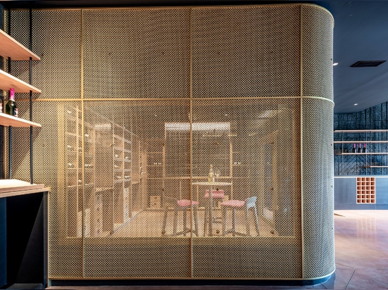 Uno spazio contemporaneo per la degustazione di vini è caratterizzato dalla rete metallica intrecciata in ottone M22-83 come divisorio per la sala di degustazione.