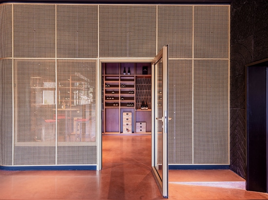 Uno spazio contemporaneo per la degustazione di vini è caratterizzato dalla rete metallica intrecciata in ottone M22-83 come divisorio per la sala di degustazione.